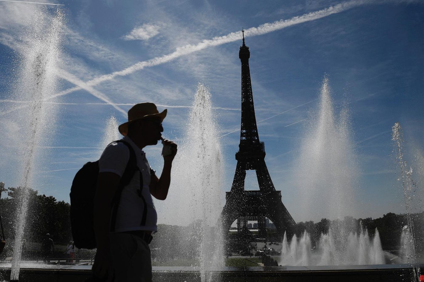 Un homme se rafraîchit dans une fontaine à Paris