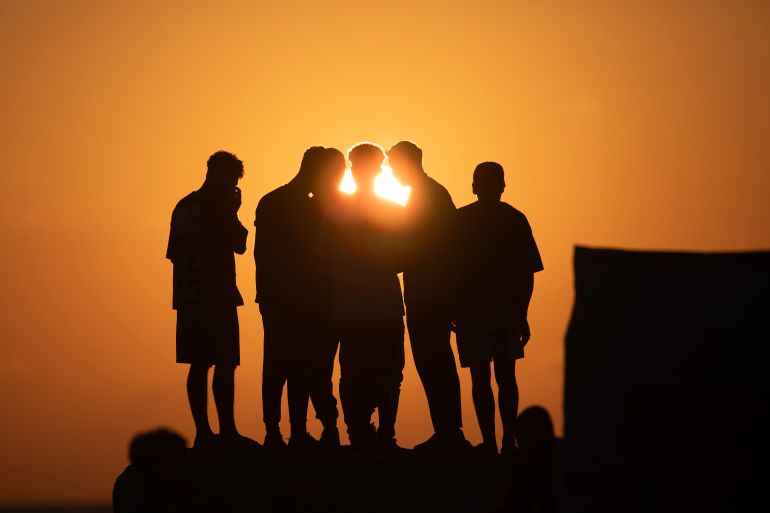Des déplacés affamés rassemblés sur la plage de Gaza au coucher du soleil