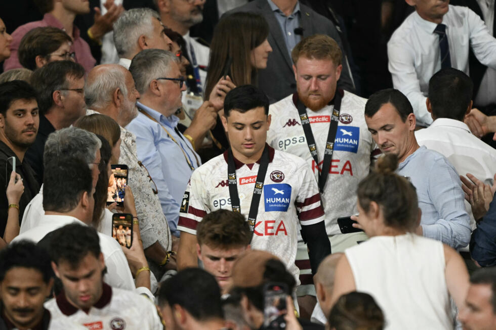 Le trois quarts aile de Bordeaux-Bègles Louis Bielle-Biarrey (C) et ses coéquipiers dans la tribune d'honneur du Stade de France pour la cérémonie protocolaire à l'issue de leur défaite en finale du Top 14 face à Toulouse (39-33), le 28 juin 2025