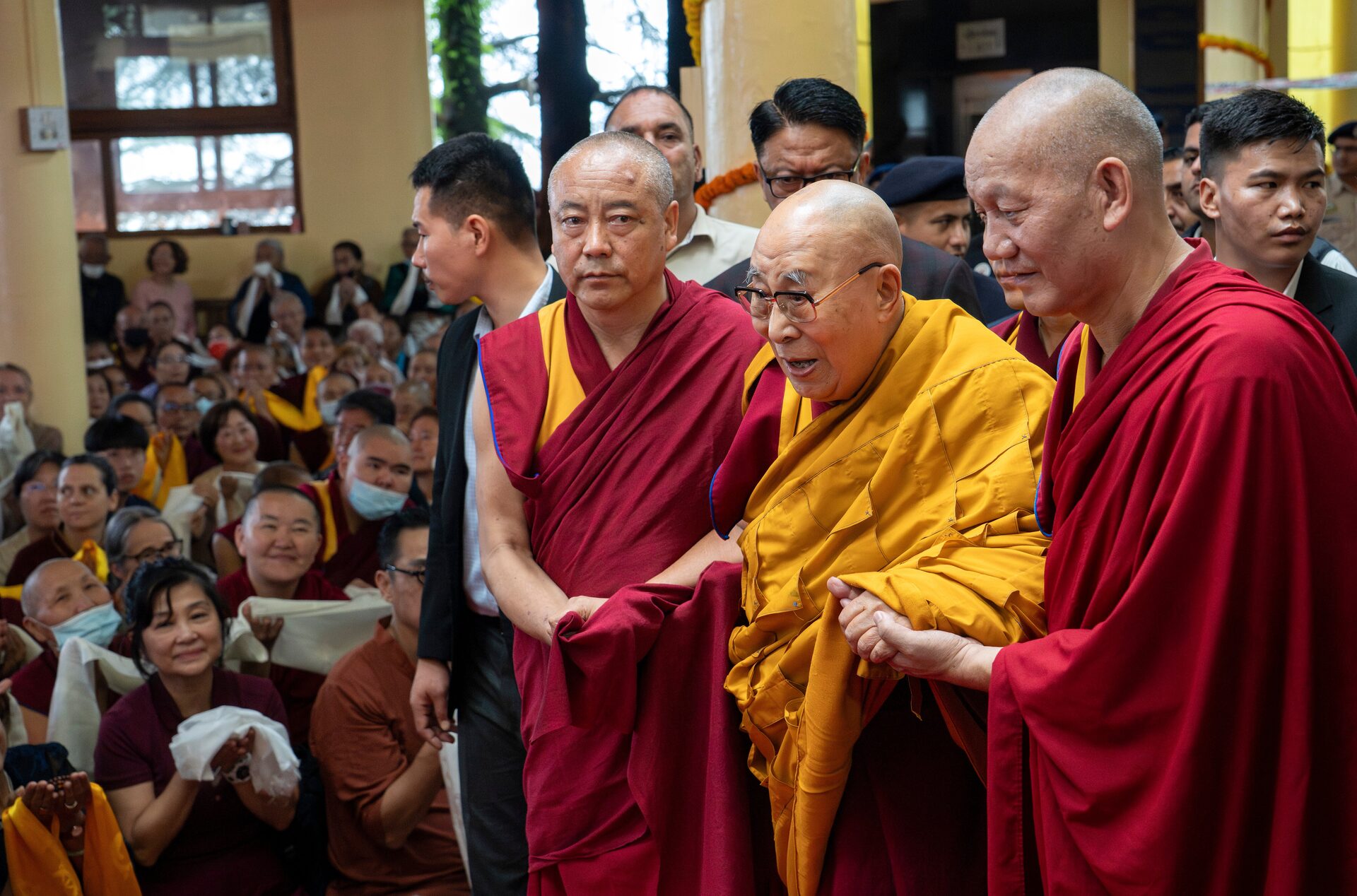 Le Dalai Lama arrive à l'événement de célébration avec des moines.