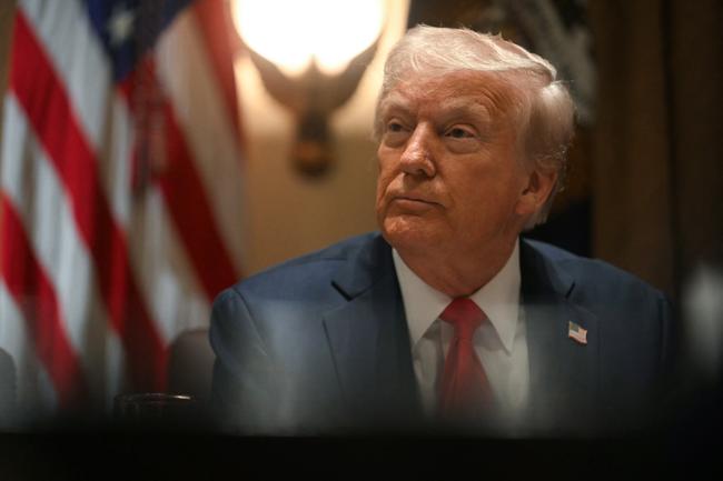 Donald Trump lors d'une allocution politique, avec un symbole de l'éducation en arrière-plan