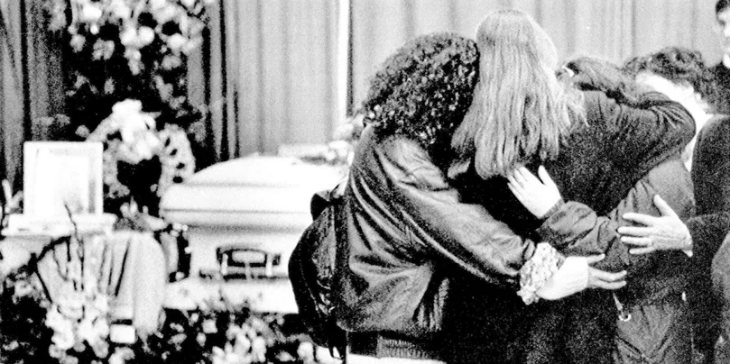 De jeunes femmes se recueillent après l'attentat à l'école Polytechnique de Montréal, ayant coûté la vie de 14 femmes.