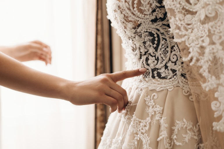 Broderie sur une belle robe de mariée, préparation pour la cérémonie, robe couture faite à la main