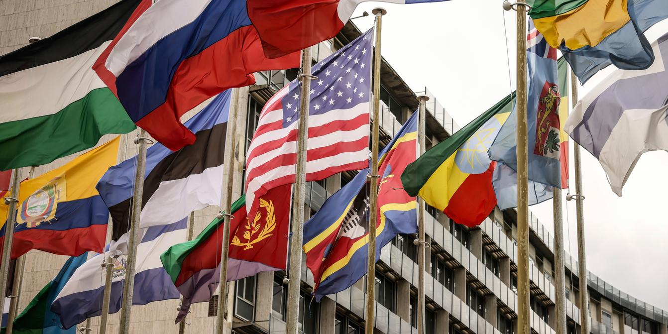 Logo de l'UNESCO avec un drapeau américain en arrière-plan