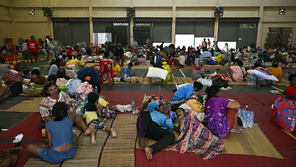 Civils évacués dans une gymnase en Thaïlande, témoignant de la crise humanitaire