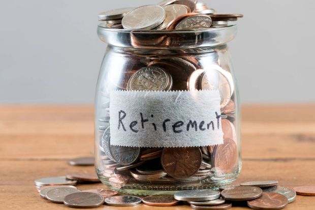 Bocal en verre rempli de pièces étiqueté 'Retraite'