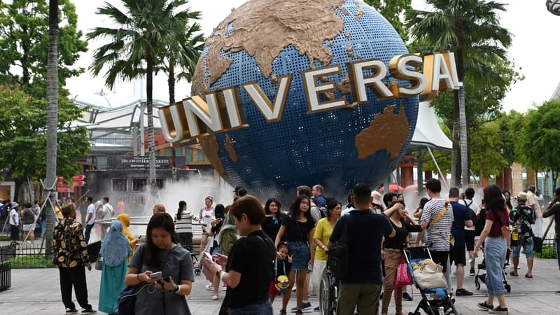 Visiteurs devant le globe d'Universal à Singapour