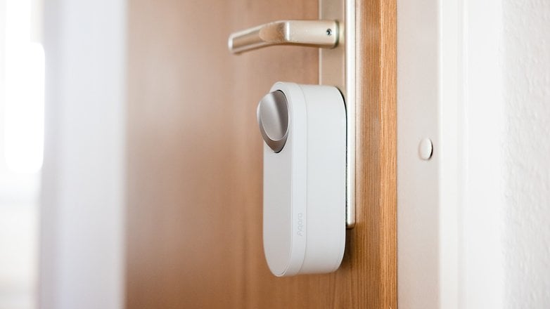 Verrou intelligent Aqara U200 Lite monté sur une porte en bois.