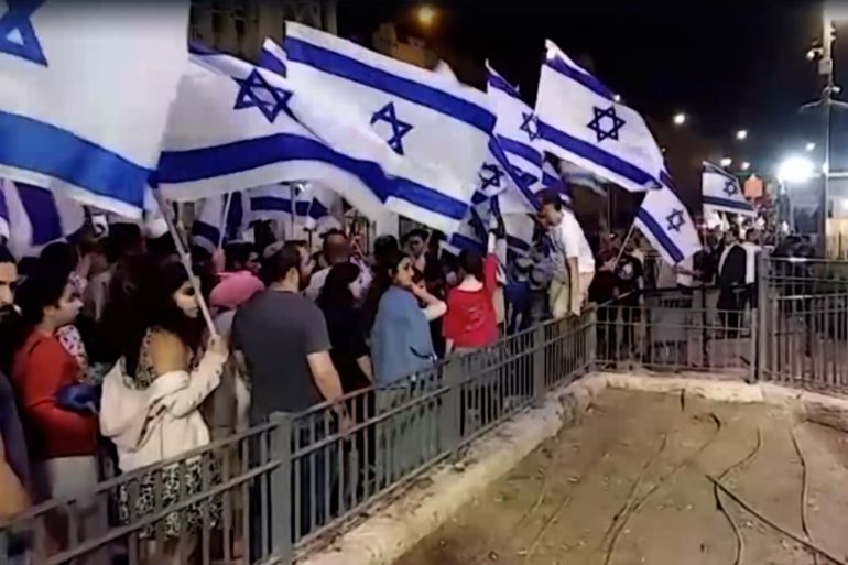 Colons rassemblés à la porte de Damas à Jérusalem brandissant le drapeau israélien lors de la commémoration de la Destruction du Temple