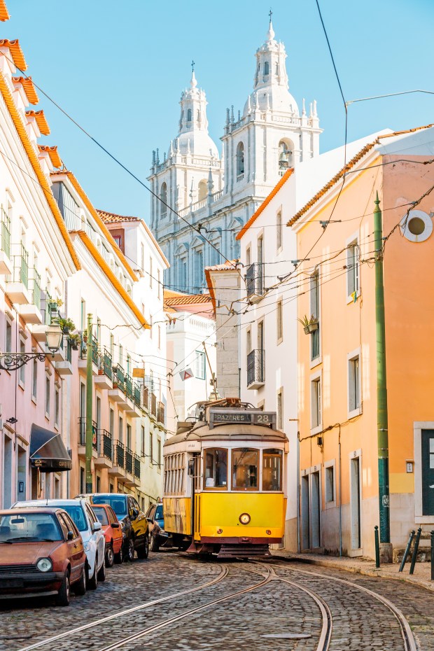 Tram jaune dans une rue pavée de Lisbonne, Portugal.