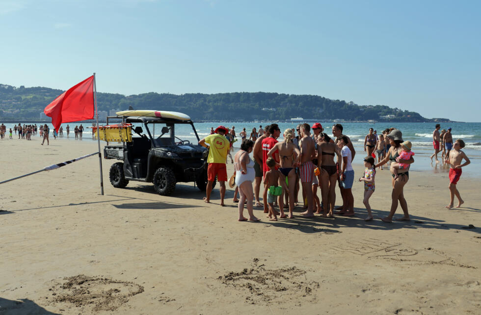 Des personnes sont rassemblées près des maîtres-nageurs sauveteurs qui ont hissé le drapeau rouge interdisant la baignade, le 4 août 2025 à Hendaye, dans les Pyrénées-Atlantiques