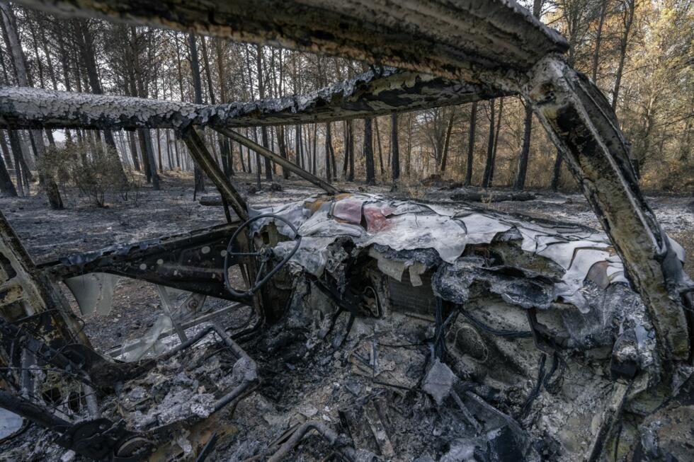 Une voiture calcinée dans une forêt après l'incendie dans l'Aude, le 9 août 2025, à Fontjoncouse.
