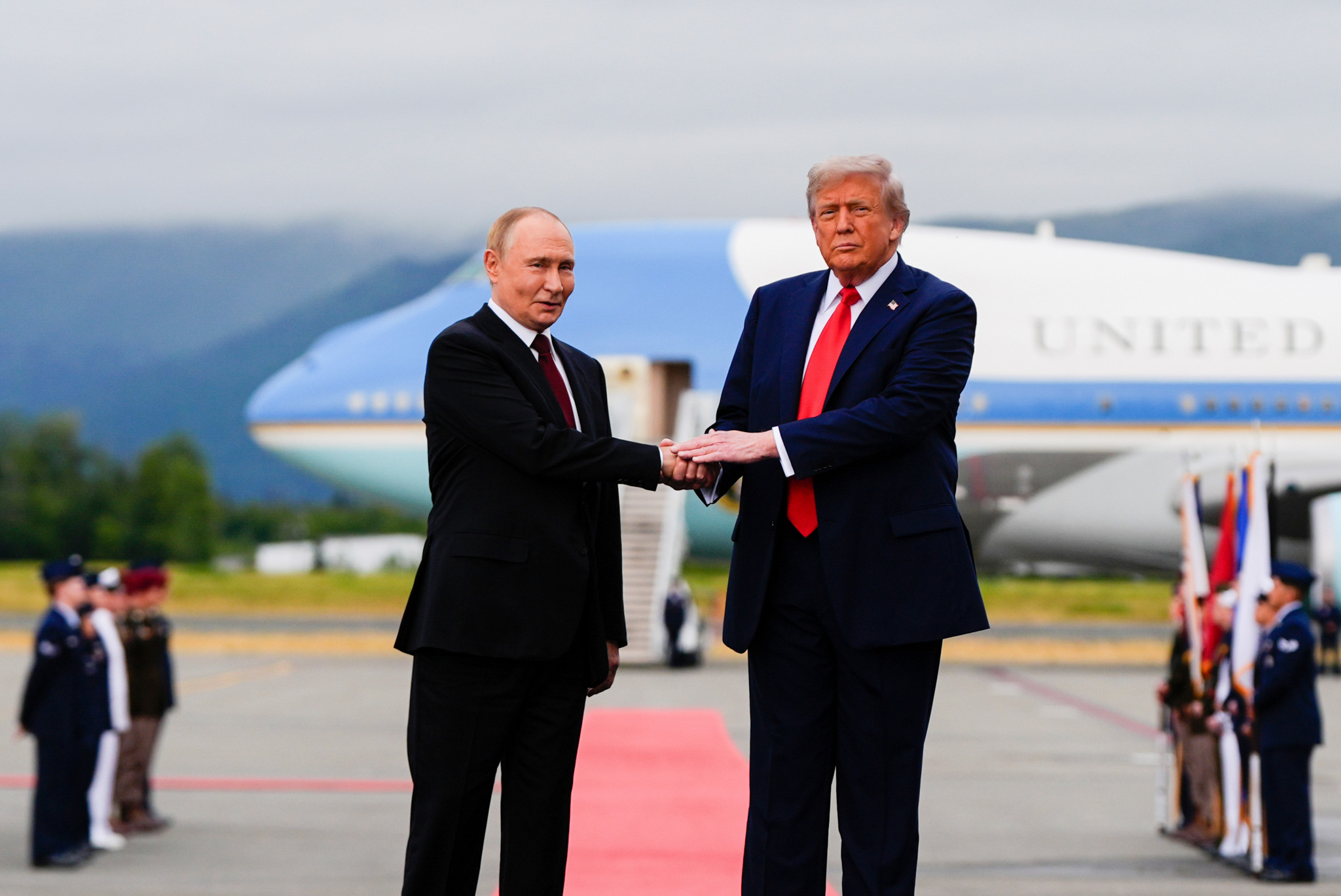 Trump et Poutine se serrent la main devant un avion