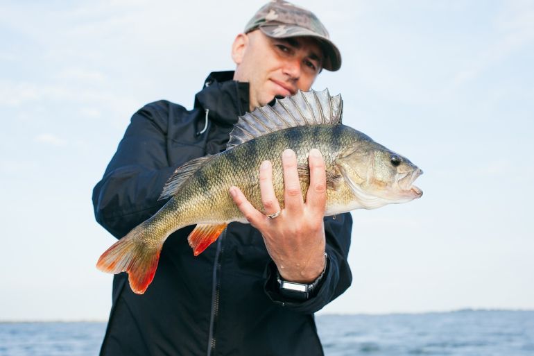 Homme tenant un poisson Frøh