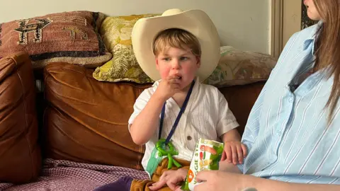 Ivan portant un chapeau de cow-boy et mangeant un en-cas
