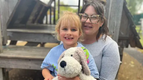 Holly avec sa fille Ayda assise sur ses genoux