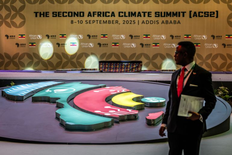 Délégué devant le visuel du Sommet africain sur le climat à l'ouverture du Sommet des dirigeants, 8 septembre 2025