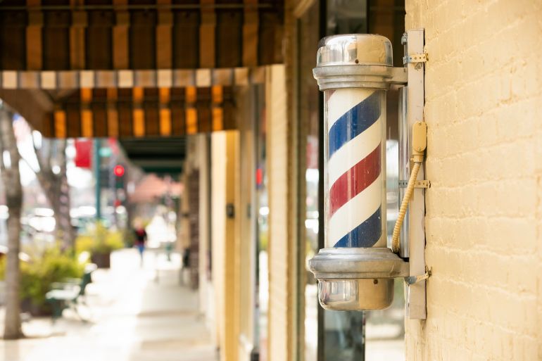 Poteau de barbier coloré devant un salon