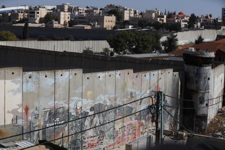 Peinture sur le mur de séparation en Cisjordanie montrant une personne ligotée emmenée par des soldats