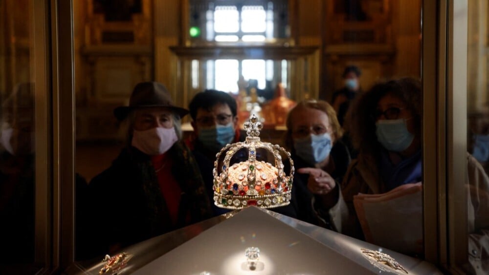 Visiteurs regardant la couronne exposée au Louvre
